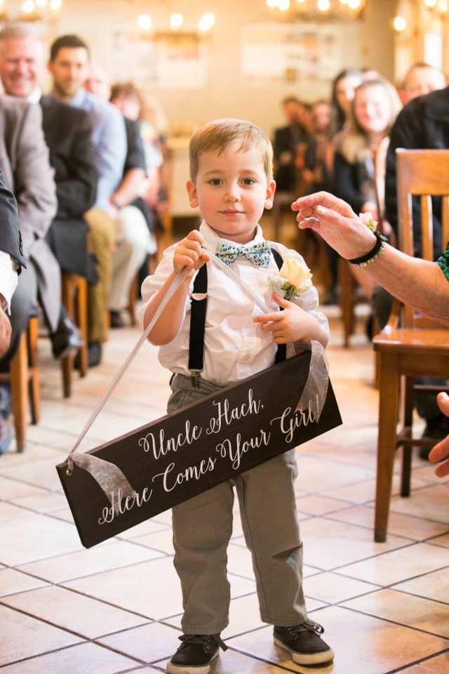 Little boy holds wedding sign at the wedding of Jessica and Justin