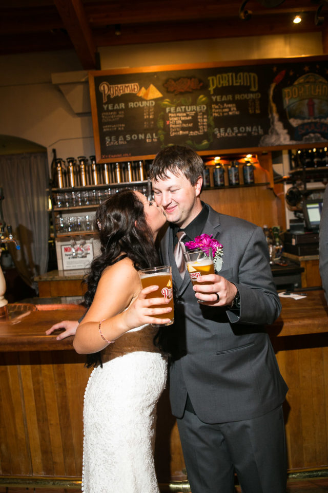 Justin and Jessica kissing and holding beers