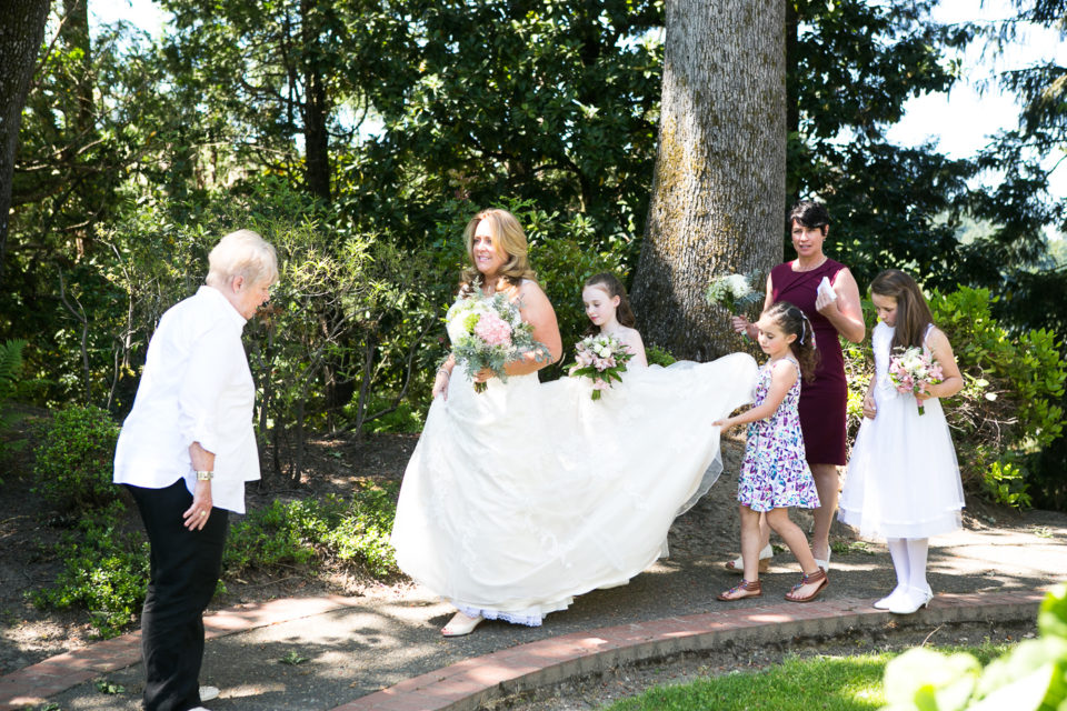 Kathryn walks to the church as her family carries her train 