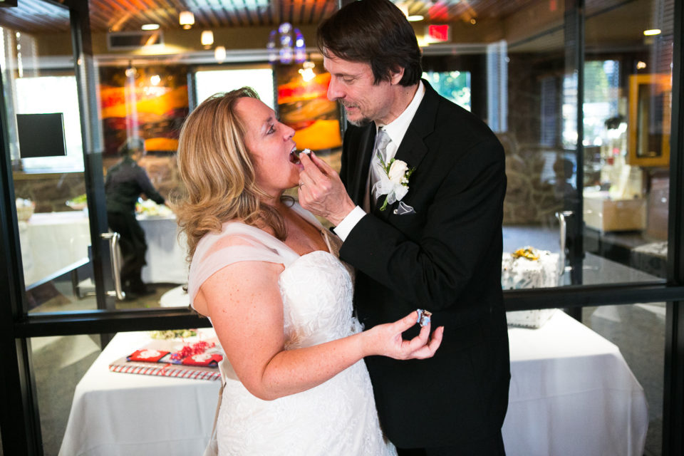 Kathryn and James share cake on their wedding day